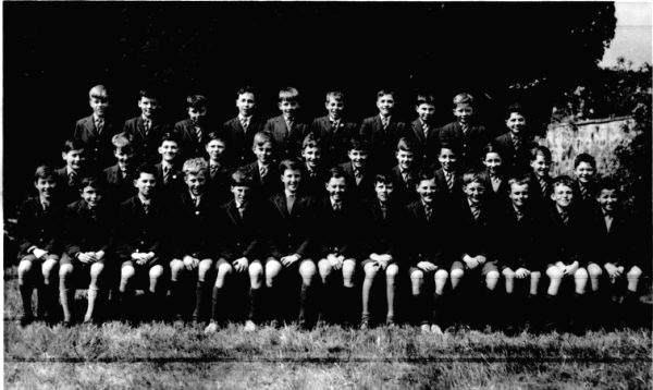 Adrian McDonald.jpg - Photo supplied by Adrian McDonald Names supplied by Sandy Gordon Back Row from the left (as seen) : Sandy Gordon, Martin Gorman, George Muldoon, Barrington Wilson, ?John Perreur-Lloyd?,  Michael Clark, John Slepokura, (forget), John Pryde, Leo Pelosi. Middle Row : (forgotten), Hugh Grant, Reno Di Rollo, Stanislaw Urbaniak?, Aidrian Kendal, (forgotten), Joe Capaldi, Hugh Lavery, Damian De Luca, Ian Beltowski, John Henderson, (forgotten) Front Row :  Neil Allan, Ian Somerville, Mike Maran, Damian Wynn-Williams,Peter Whiston, (forgotten), Ian McSporran?, Glenn Ross, Peter Flynn, Hugh Walsh, (forgotten), (forgotten), Eion Coltart.  I think Damian Wynn Williams left 1963 or 1964. John Pryde left when he was 15 We are all wearing shorts, so, is this P7? or perhaps P6? 1959 or 1960?